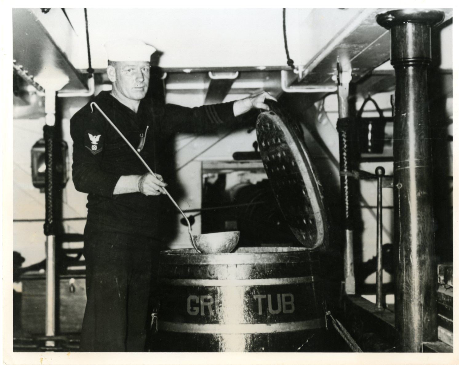 An unidentified Boatswain's Mate contemplates the grog tub in the 1930s.  [USS Constitution Museum Collection.]