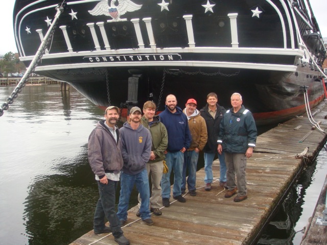 Seward Marine Services, Inc. divers pose in front of USS Constitution after working on her hull. [Courtesy Seaward Marine Services, Inc.]