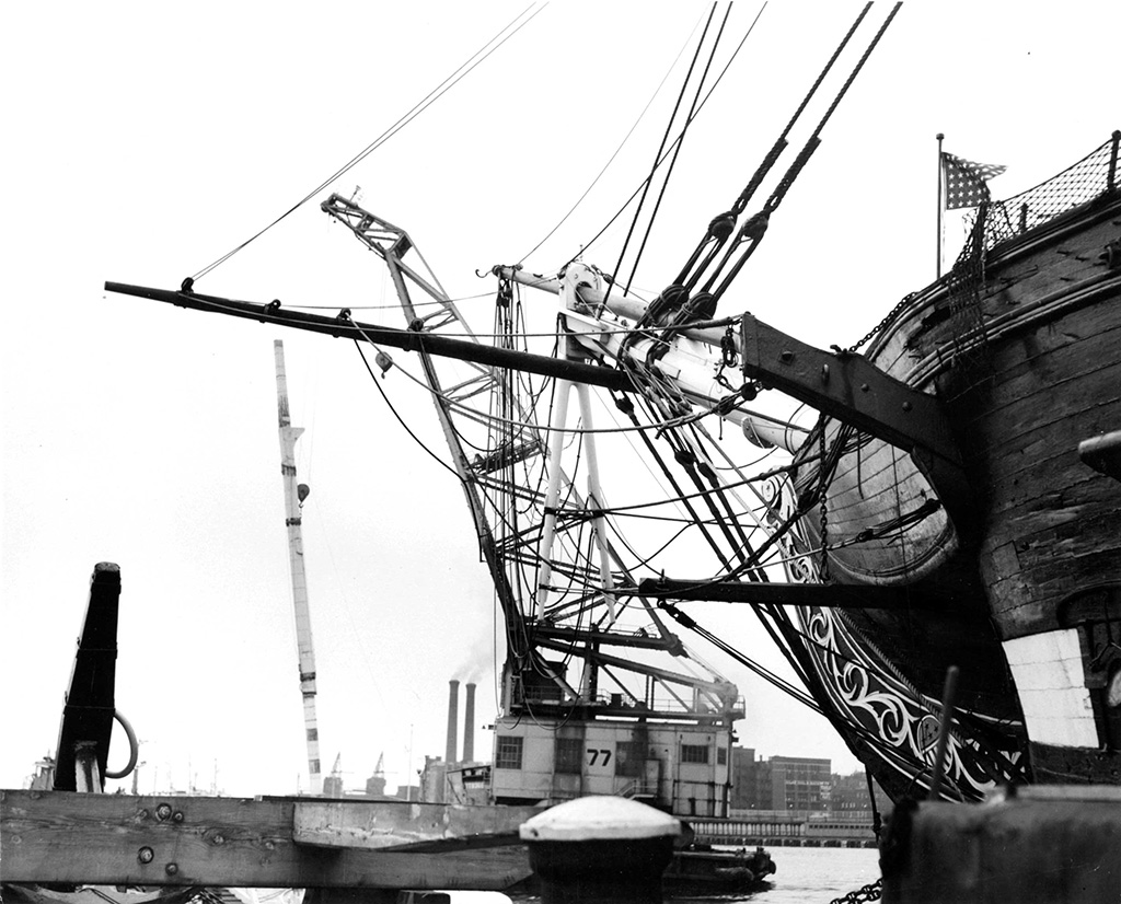 A floating crane lifts a mast in the 1950s. [Courtesy Naval History & Heritage Command Detachment Boston]