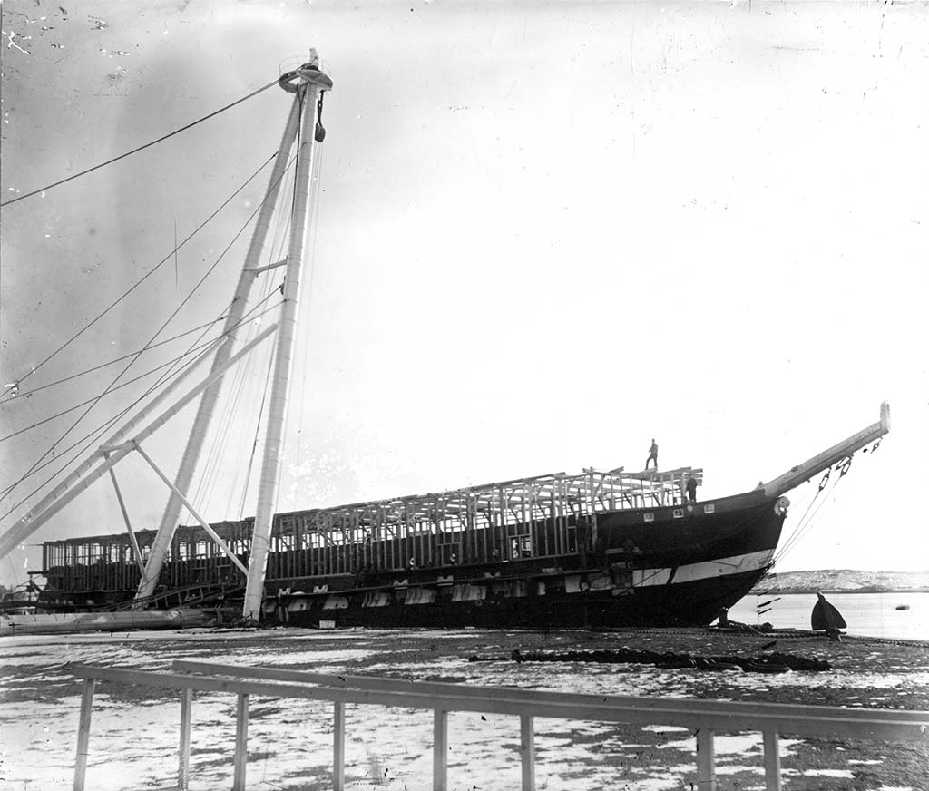Pierside sheer legs and block and tackle are used to construct the receiving ship barn on Constitution in 1882-3 at the Portsmouth Naval Shipyard. [Courtesy Strawbery Banke Museum]