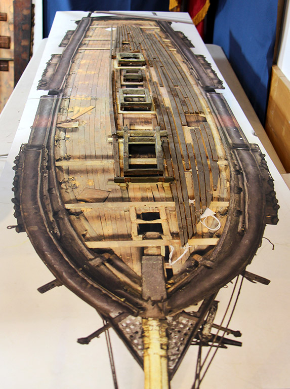 In December 2015, planks removed from the Loring model for cleaning are laid over a panoramic photo of the unrestored model. [Courtesy USS Constitution Museum]