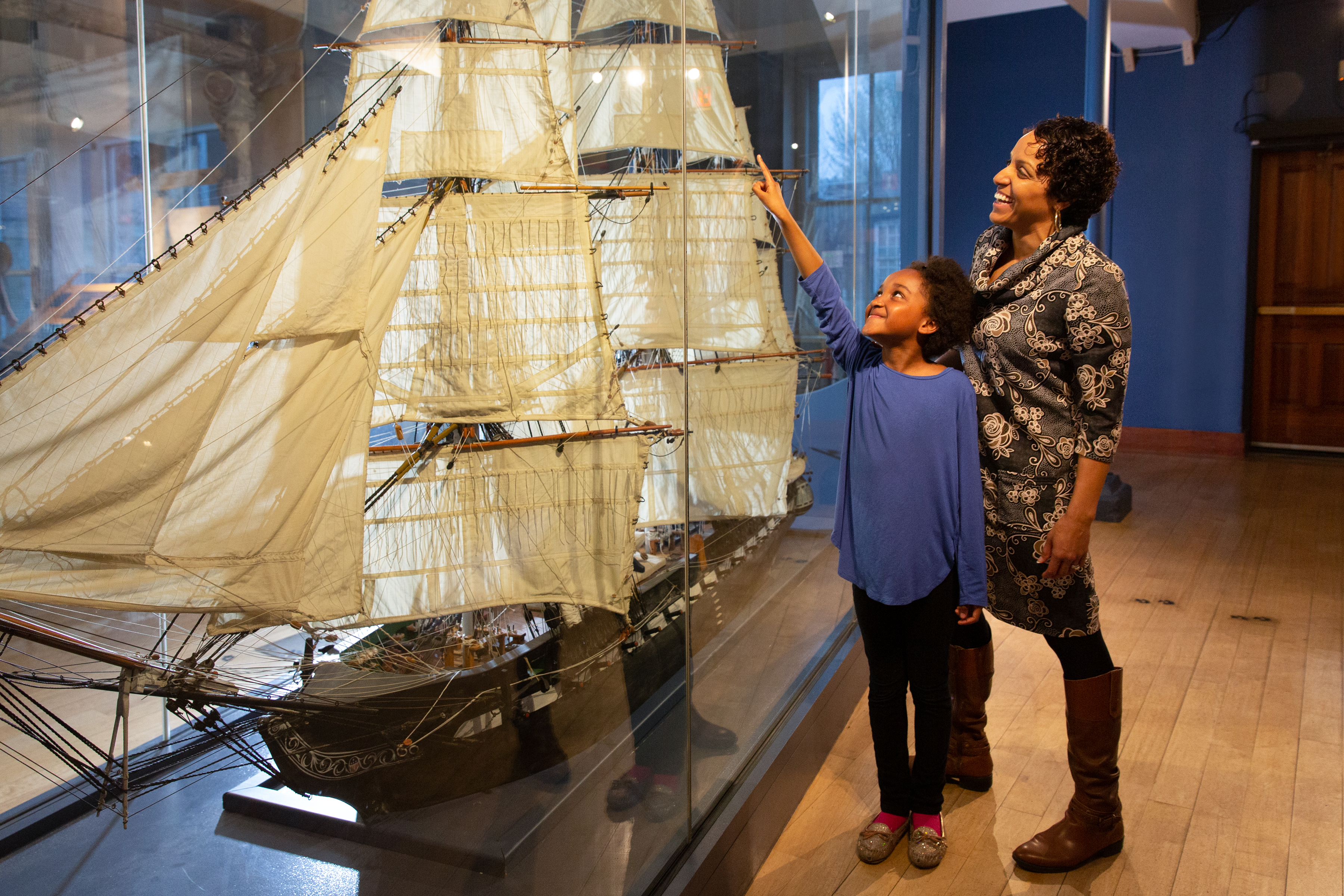 Girl and daughter viewing large ship model of USS Constitution