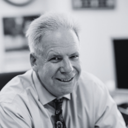 Headshot of smiling man wearing tie in collard shirt