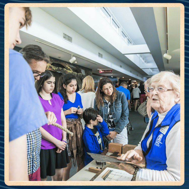 Woman instructs children in an activity in a museum